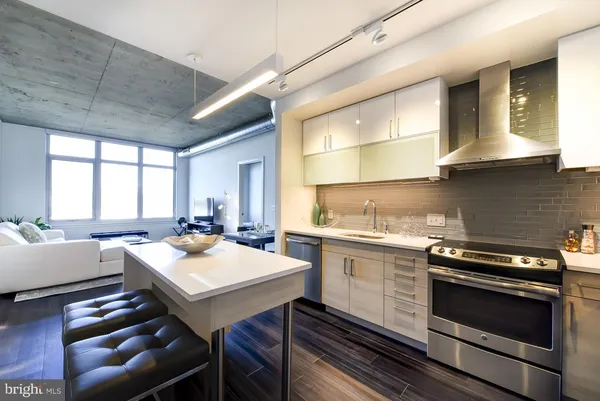 a kitchen with a stove a sink and chairs