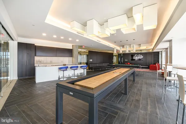 a living room with stainless steel appliances furniture and a kitchen view