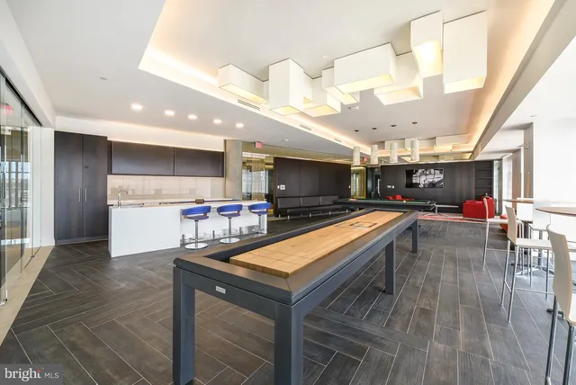 a living room with stainless steel appliances furniture and a kitchen view