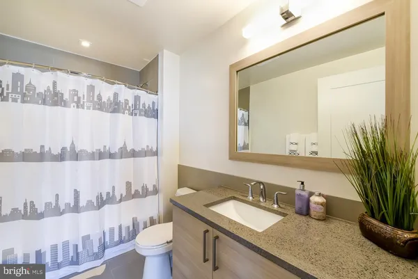 a bathroom with a granite countertop sink and a mirror