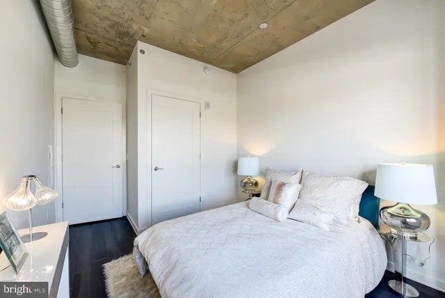 a bedroom with a bed and wooden floor