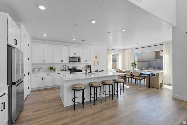 382 North Rhyolite Drive, Unit 111 Hurricane, UT 84737 - Photo 31 of 37 Spacious kitchen featuring white cabinetry, stainless steel appliances, and a central island with countertop seating