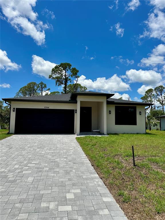 a front view of a house with a yard and garage