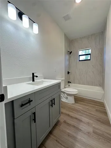 a bathroom with a double vanity sink toilet and shower