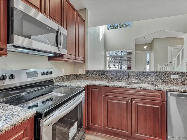 a kitchen with stainless steel appliances granite countertop a stove and a sink
