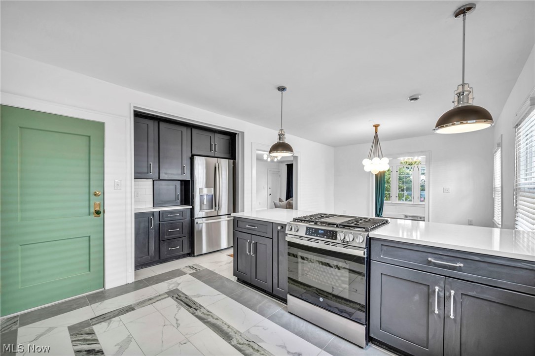 2135 Coventry Road, Unit DOWN Cleveland, OH 44118 - Photo 15 of 34 Kitchen featuring stainless steel appliances, light stone counters, pendant lighting, and light marble finish floors
