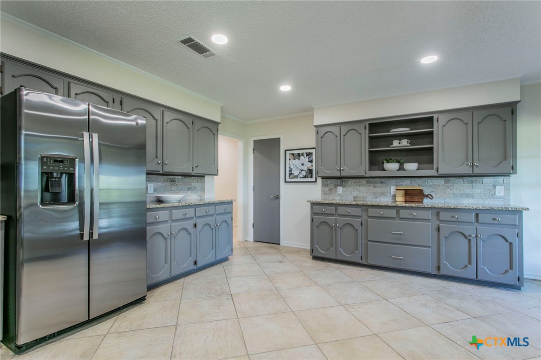 608 Ridgecrest Drive Salado, TX 76571 - Photo 11 of 43 a large kitchen with stainless steel appliances granite countertop a refrigerator and a stove top oven