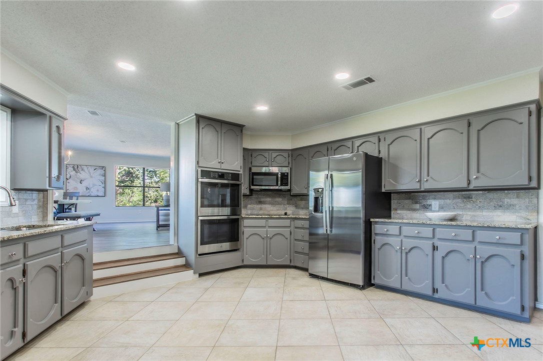 608 Ridgecrest Drive Salado, TX 76571 - Photo 12 of 43 a kitchen with stainless steel appliances granite countertop a refrigerator and a sink
