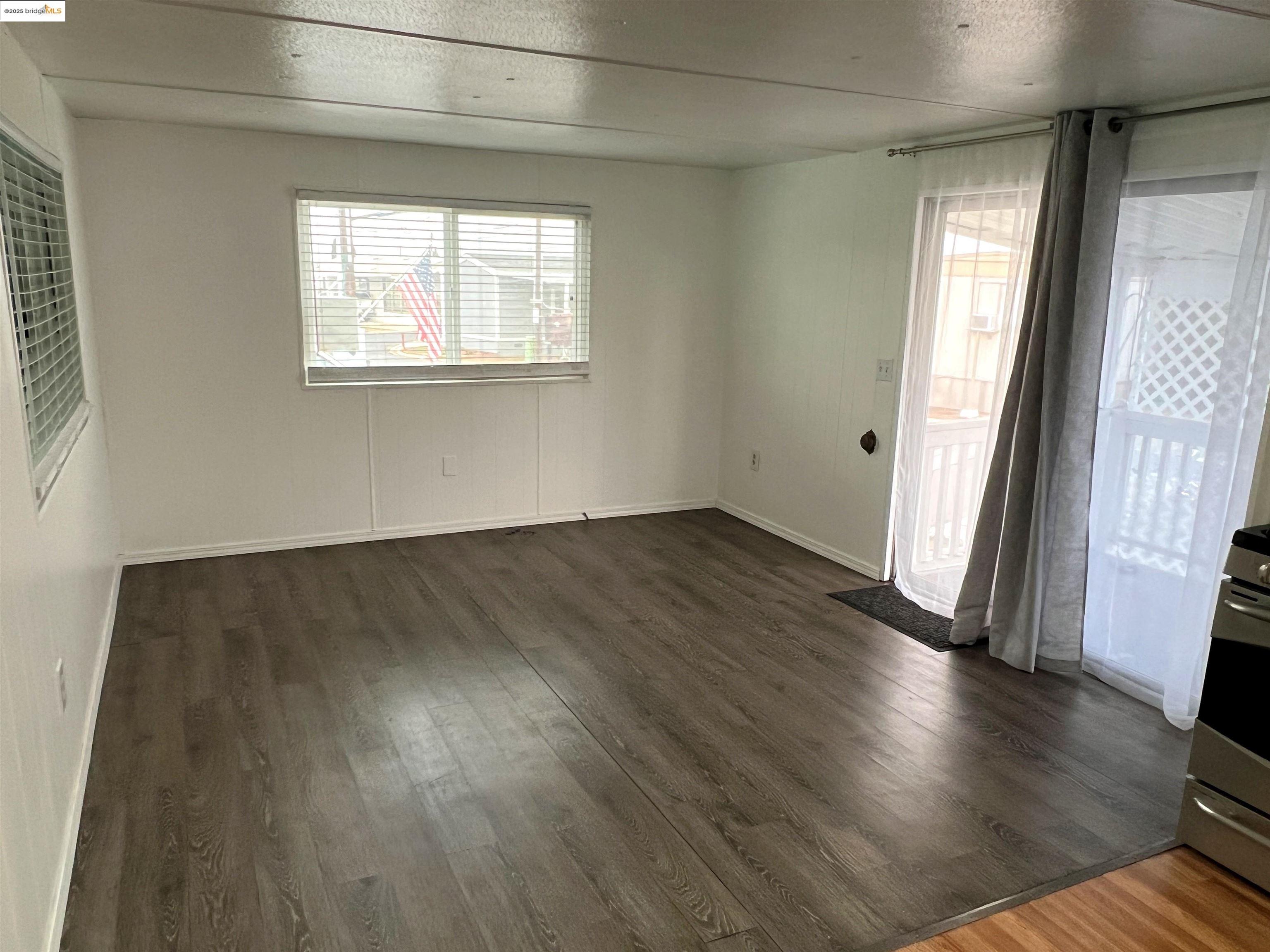 210 West Cypress Road, Unit 1 Oakley, CA 94561 - Photo 5 of 16 an empty room with wooden floor and windows
