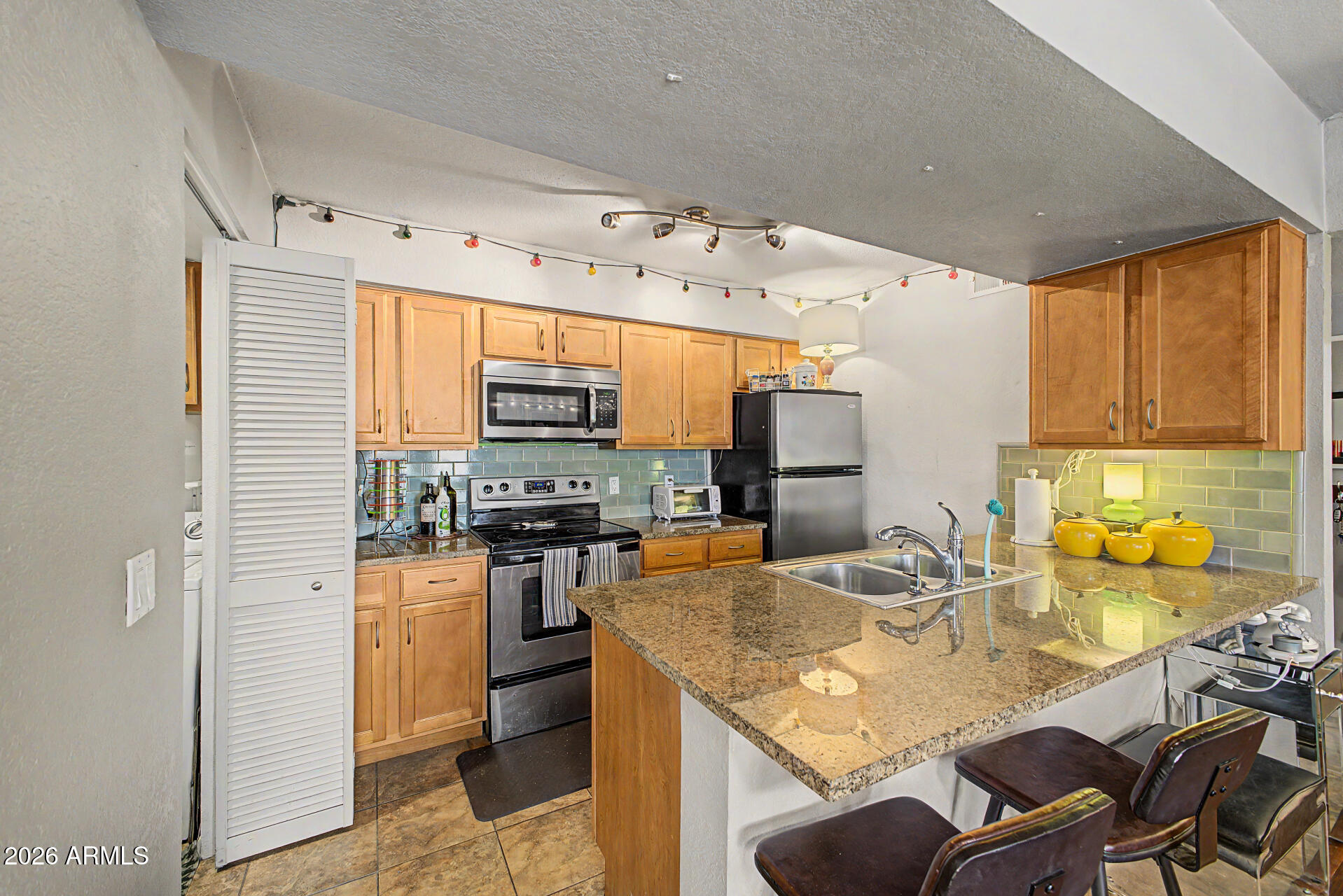 200 East Southern Avenue, Unit 224 Tempe, AZ 85282 - Photo 30 of 30 a kitchen with stainless steel appliances granite countertop a sink stove and refrigerator