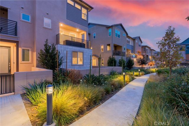 a view of a house with a garden and pathway