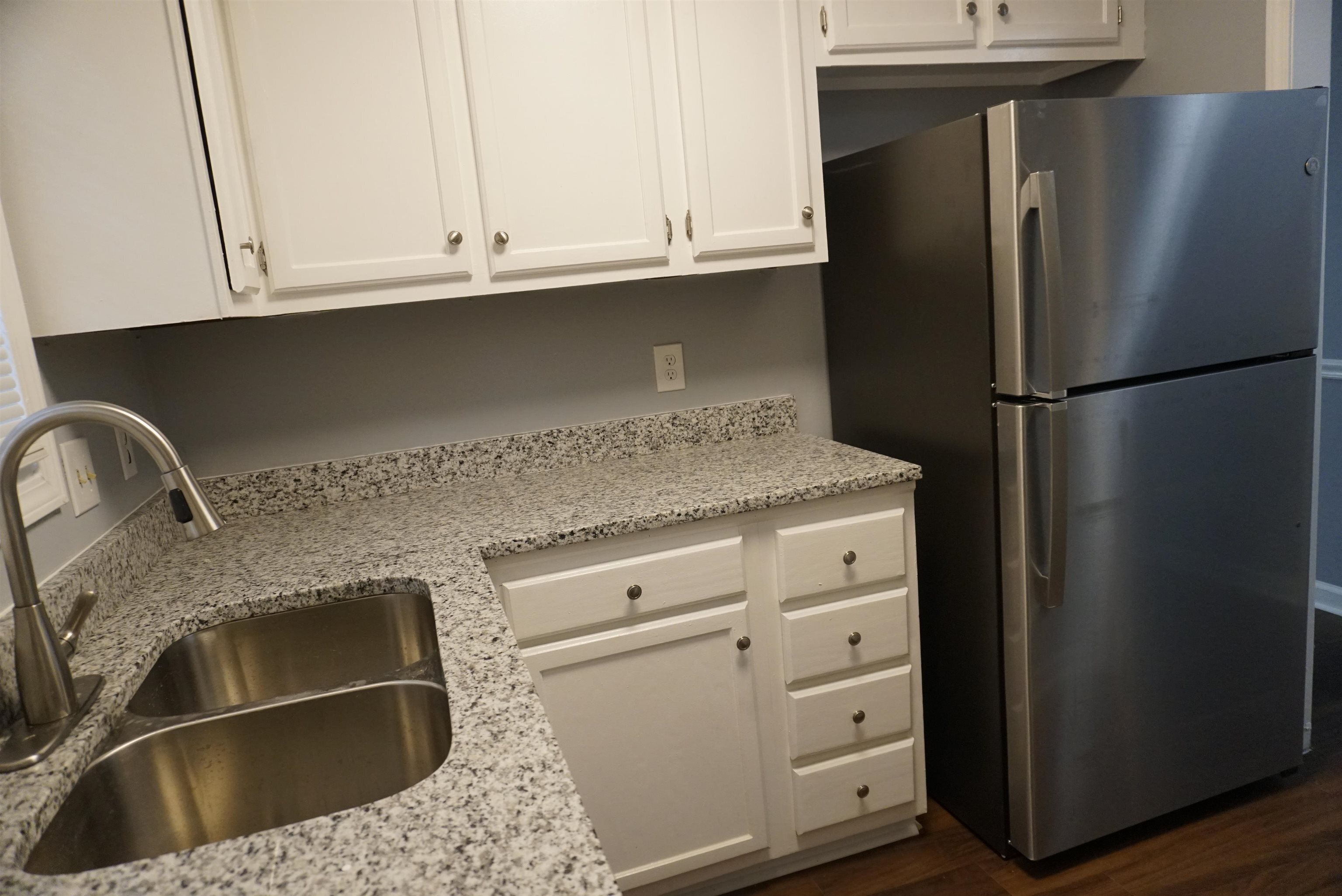 5489 South Park Place Atlanta, GA 30349 - Photo 13 of 37 a kitchen with granite countertop white cabinets and refrigerator