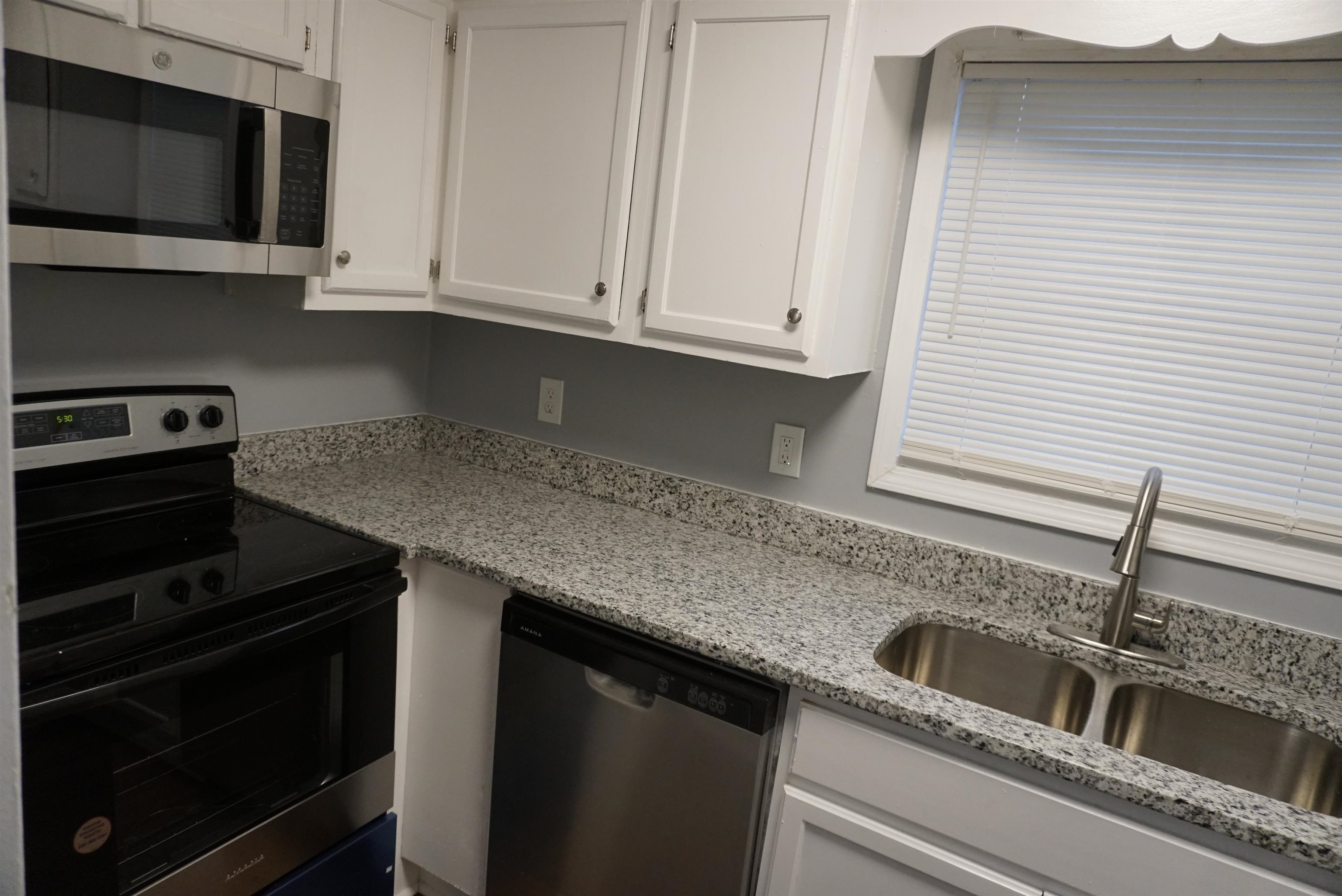 5489 South Park Place Atlanta, GA 30349 - Photo 14 of 37 a kitchen with granite countertop white cabinets and a stove