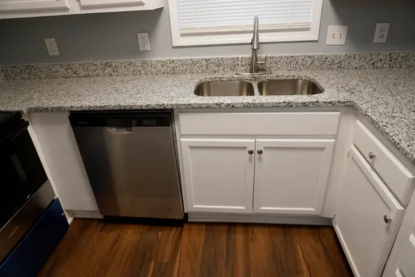 a kitchen with granite countertop a sink and cabinets