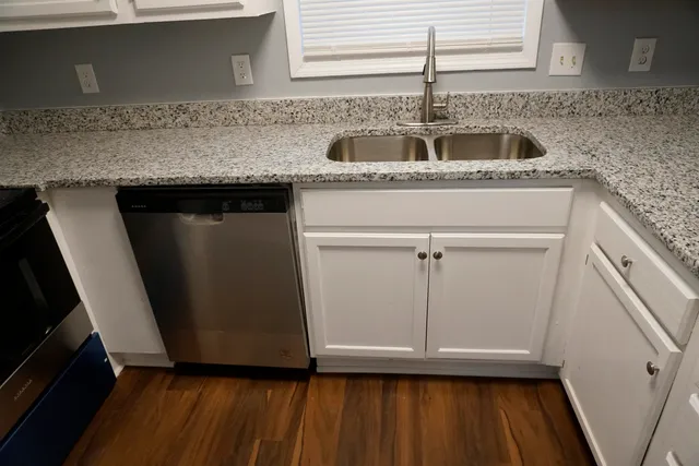 a kitchen with granite countertop a sink and cabinets