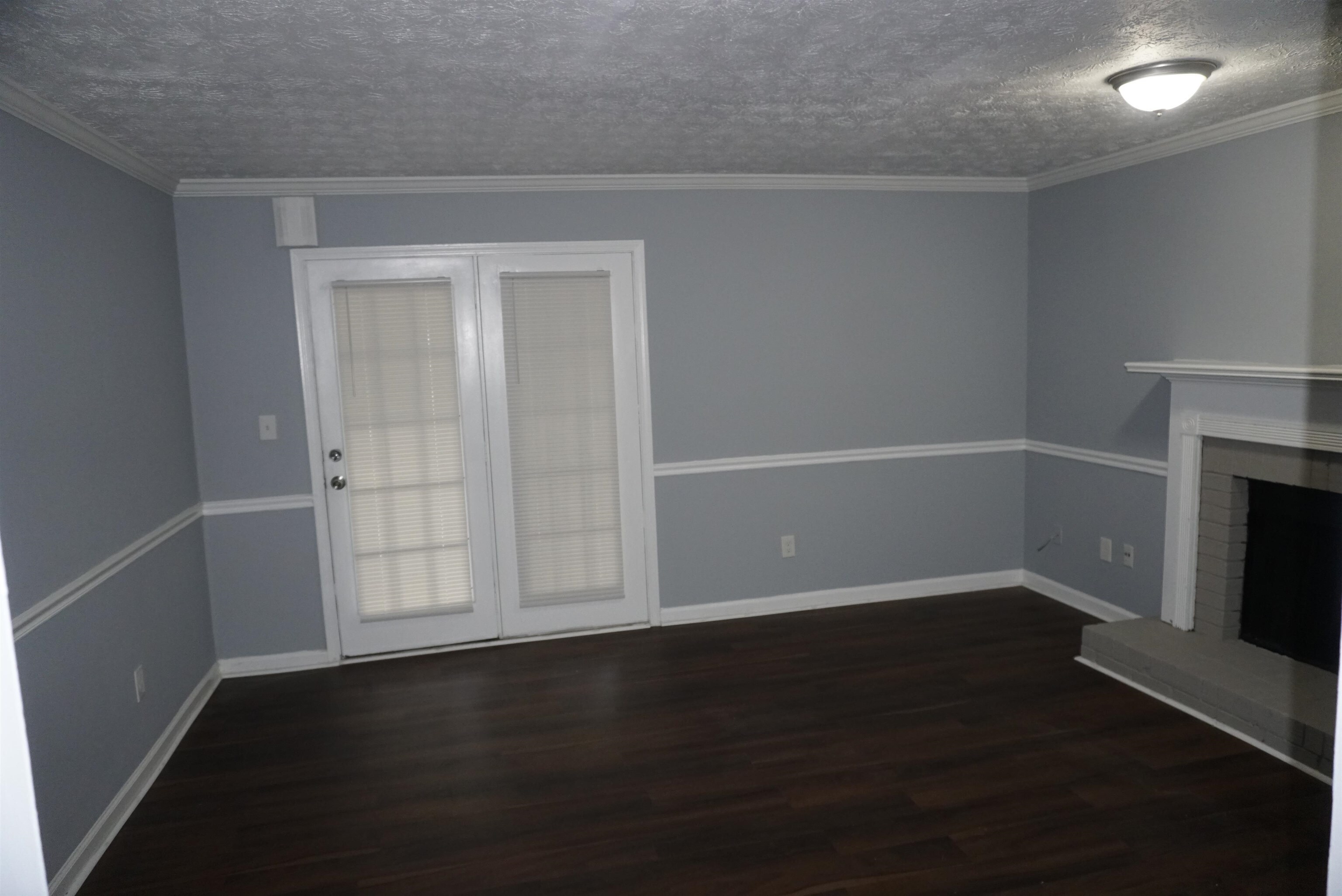 5489 South Park Place Atlanta, GA 30349 - Photo 17 of 37 an empty room with wooden floor fireplace and windows
