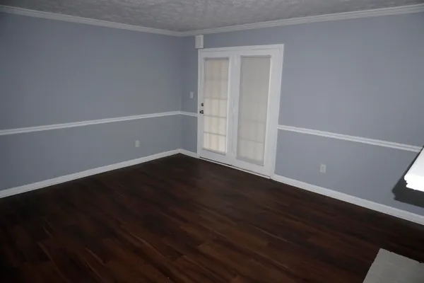 a view of a small space with wooden floor and a window