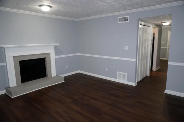 an empty room with wooden floor and fireplace