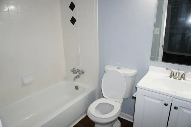 a white toilet sitting next to a bath tub