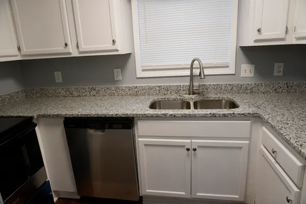 a kitchen with granite countertop a sink and cabinets