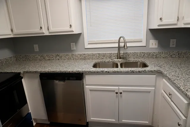 a kitchen with granite countertop a sink and cabinets