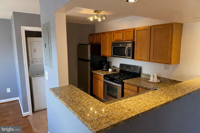 a kitchen with granite countertop wooden cabinets and stainless steel appliances