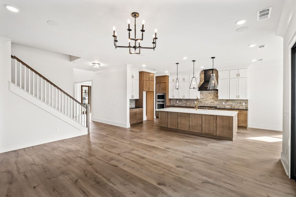 5133 Rambler Loop Franklin, TN 37064 - Photo 10 of 20 a kitchen with stainless steel appliances kitchen island wooden floors and white cabinets