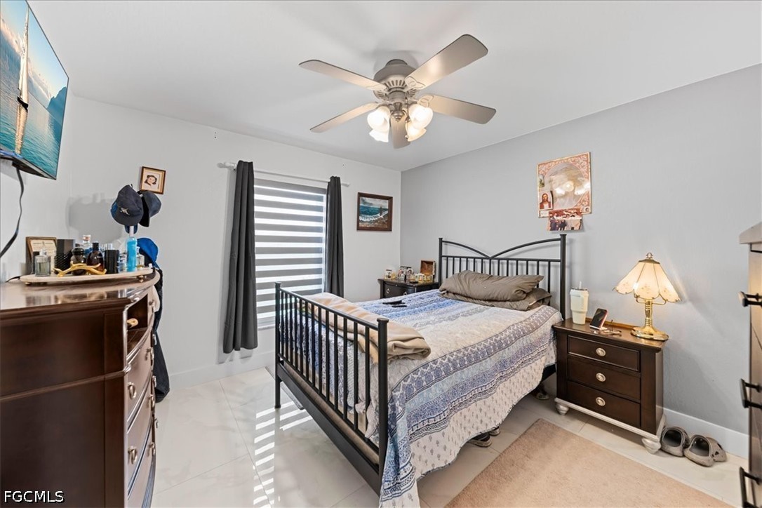 22 Nelson Road South Cape Coral, FL 33991 - Photo 25 of 43 a bed room with a bed and a chandelier