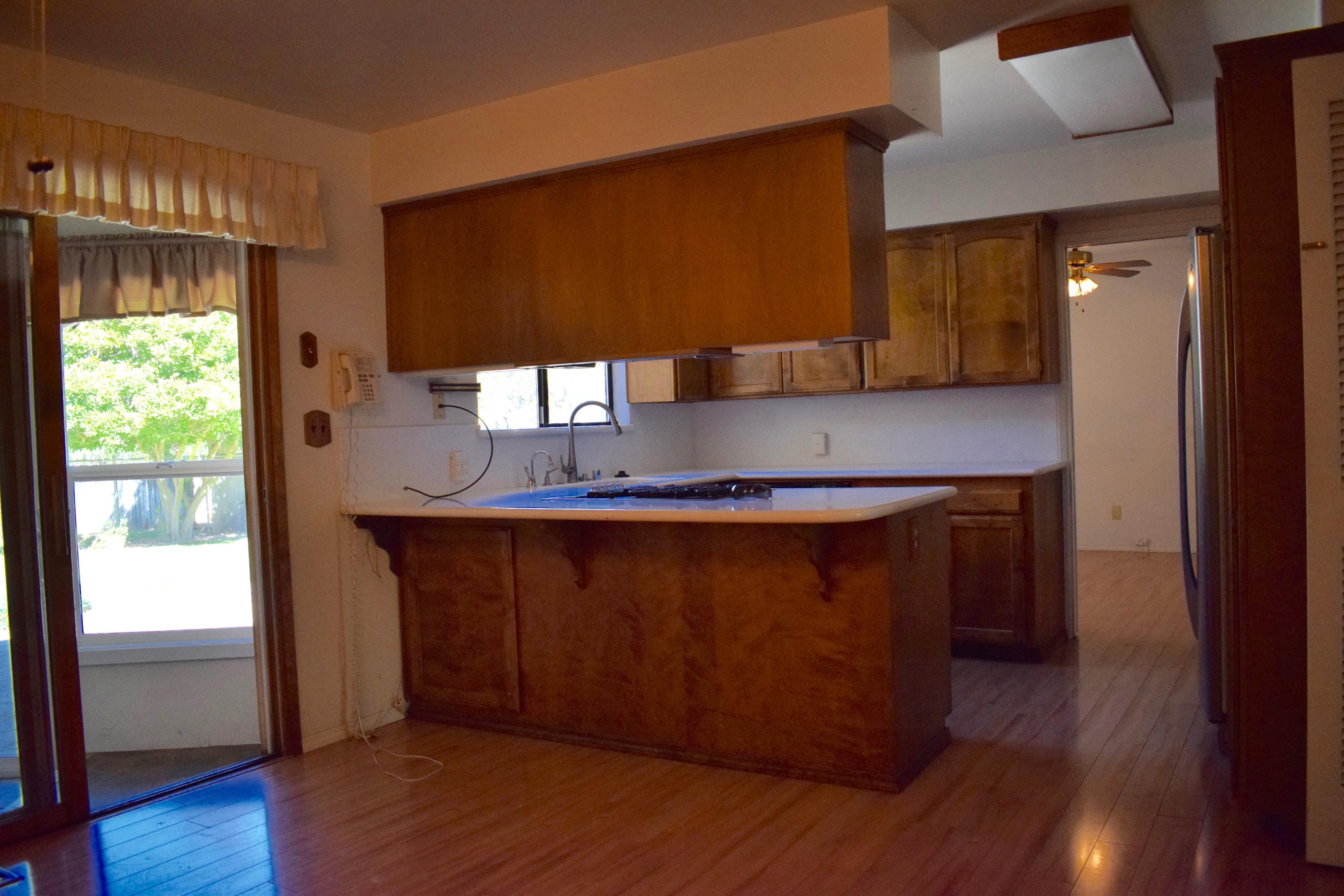 8585 Redbank Road Redding, CA 96001 - Photo 8 of 37 a kitchen with wooden floors and wooden cabinets