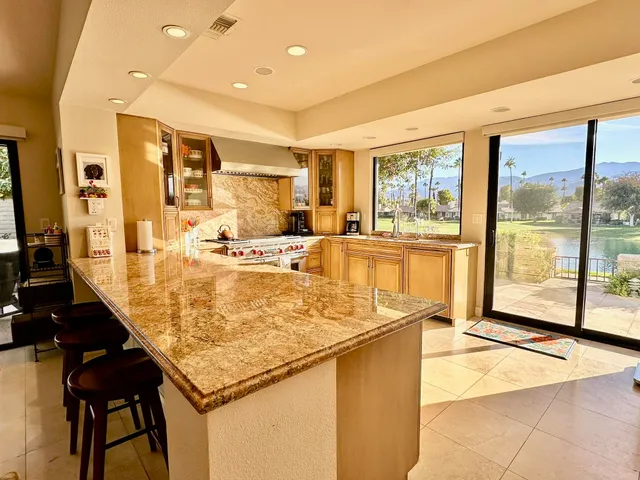 a large kitchen with kitchen island a sink a stove and a refrigerator