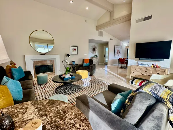 a living room with furniture a flat screen tv and a fireplace