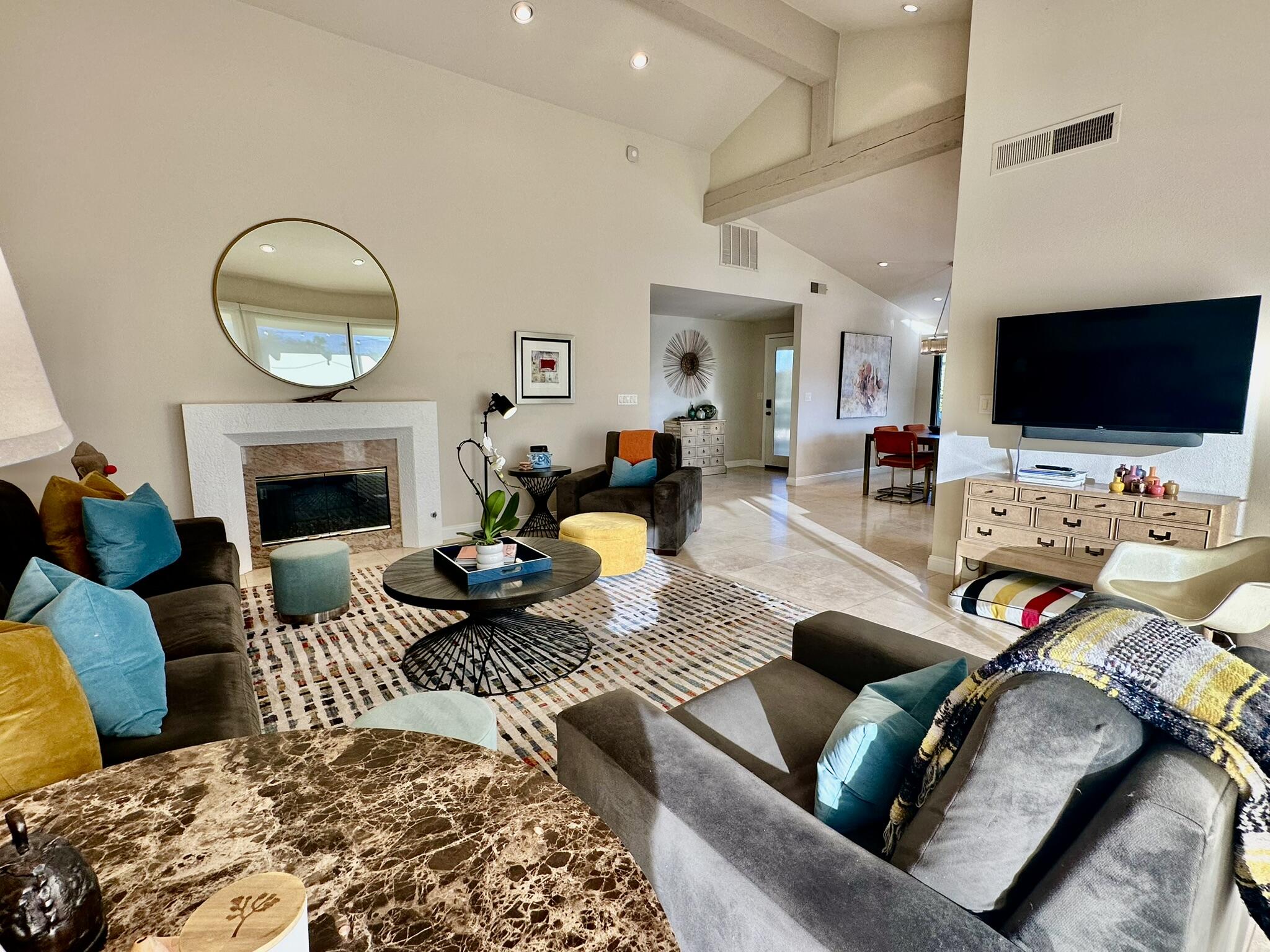 359 Villena Way Palm Desert, CA 92260 - Photo 16 of 27 a living room with furniture a flat screen tv and a fireplace