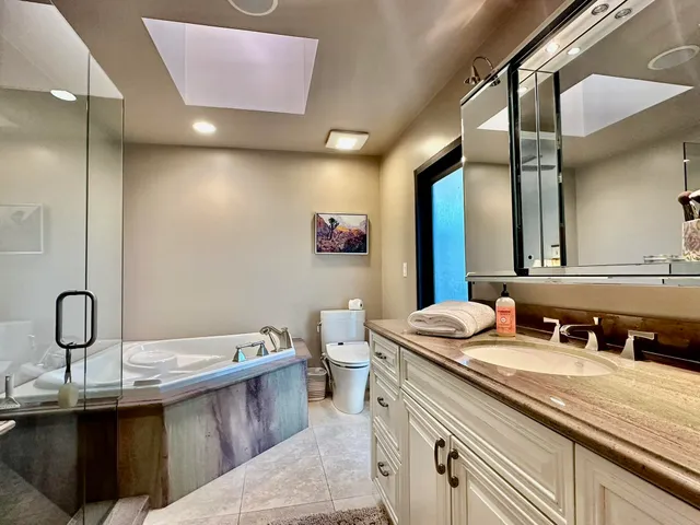 a bathroom with a granite countertop sink a mirror and a shower