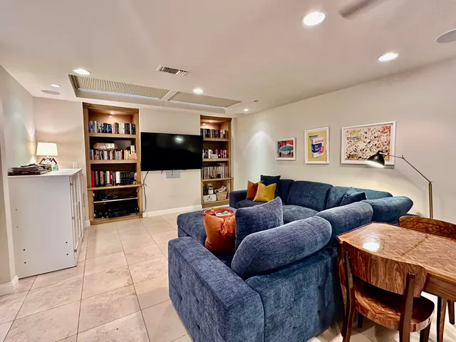 a living room with furniture and workspace