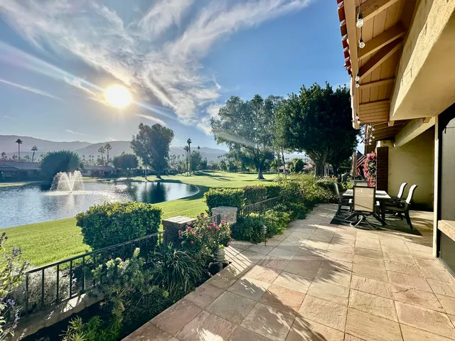 a view of a lake with a bench and a big yard