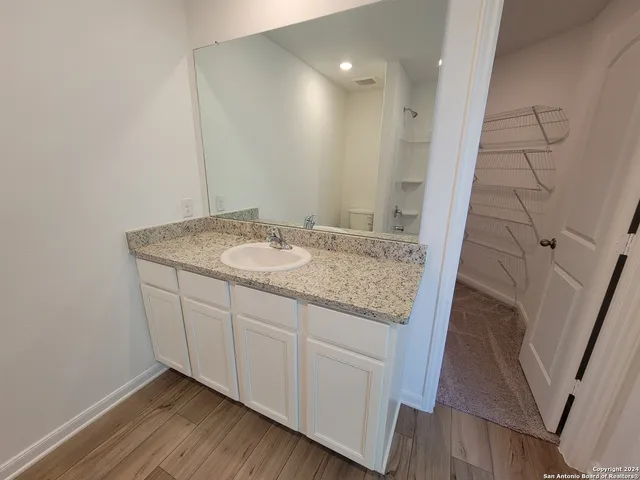 a bathroom with a granite countertop sink and a mirror