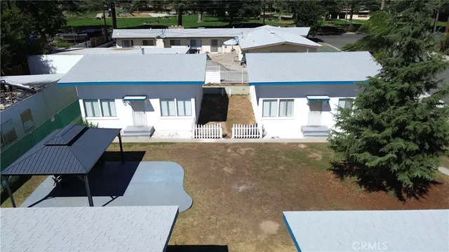 a aerial view of a house with swimming pool and large trees