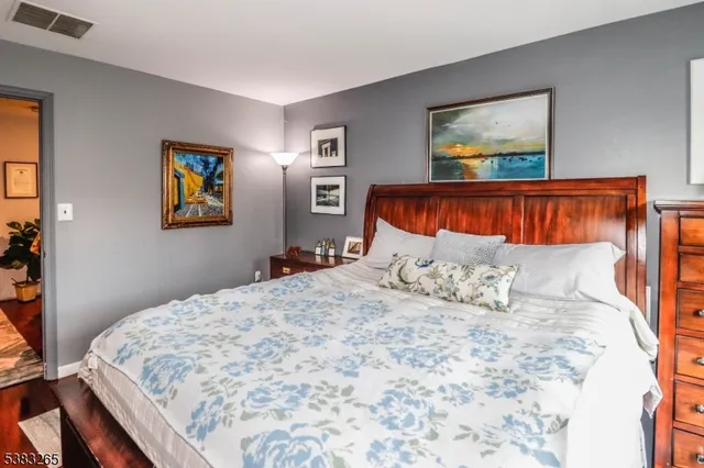 a bedroom with a large bed and a painting on the wall