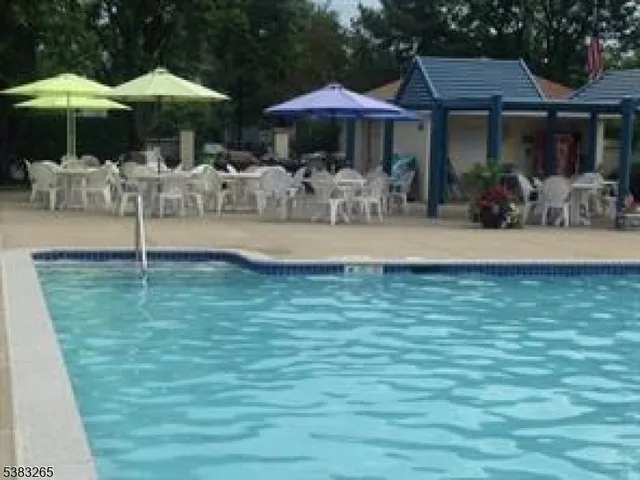 a backyard of a house with table and chairs under an umbrella