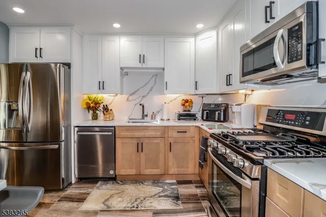 a kitchen with stainless steel appliances granite countertop a stove a refrigerator and a microwave