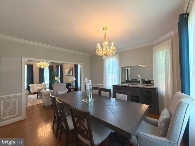 a view of a dining room with furniture wooden floor and chandelier