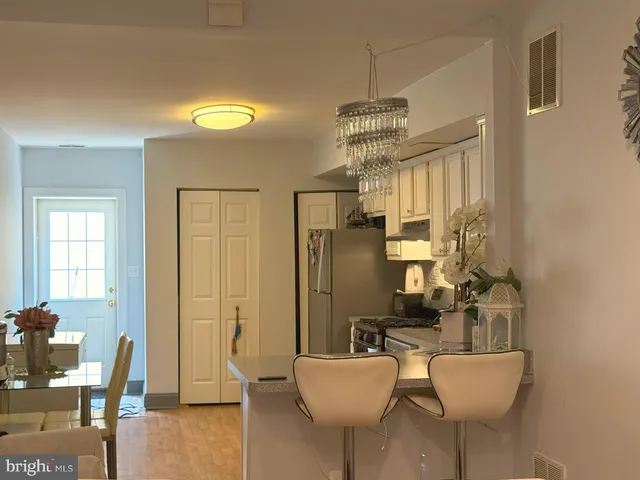a living room with furniture a chandelier and a dining table