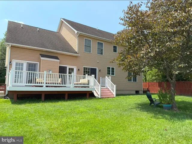 a view of a house with a backyard and a deck