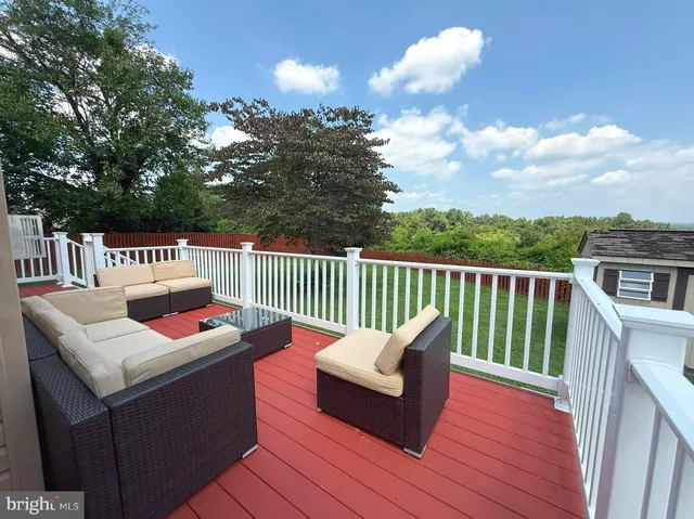 a roof deck with couches and wooden floor