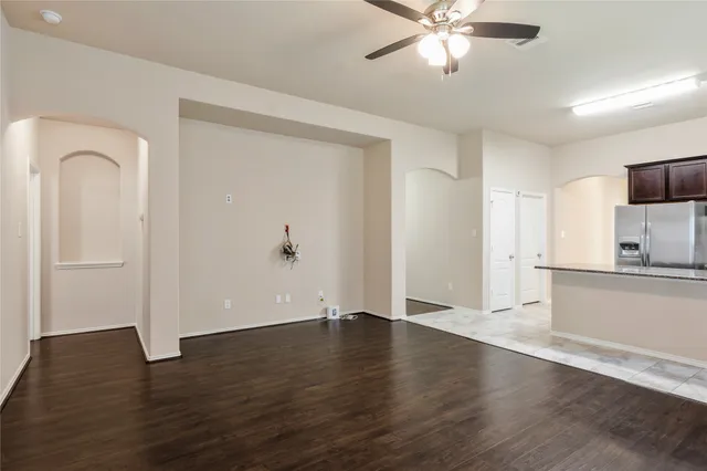 a view of an empty room with window and wooden floor