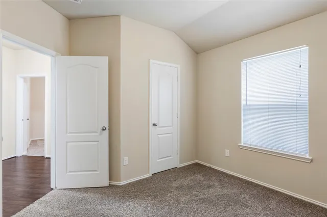 an empty room with windows and closet