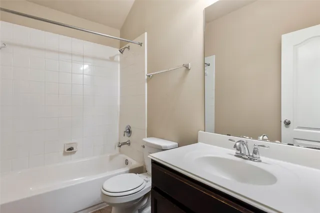 a bathroom with a sink a toilet and a large mirror