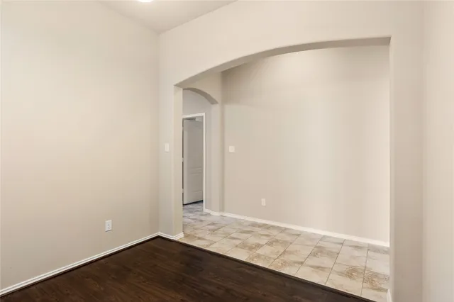 a view of an empty room with wooden floor and closet