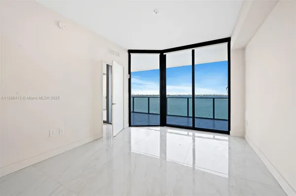 an empty room with sliding door and windows