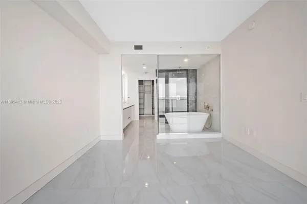 a view of a big room with wooden floor and windows
